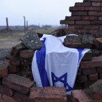 An Israeli national flag is seen at destroyed barracks at former German Nazi concentration and extermination camp Auschwitz-Birkenau near Oswiecim