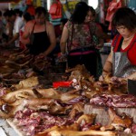 Vendors cut butchered dogs at a dog meat market ahead of local dog meat festival in Yulin